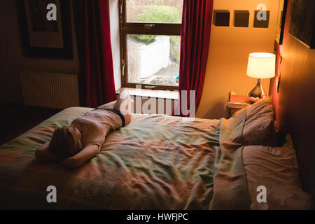 Woman lying on the bed in bedroom Stock Photo