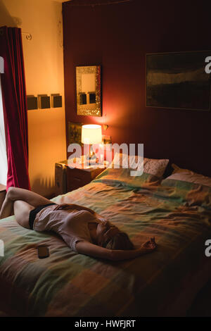 Woman lying on the bed in bedroom Stock Photo