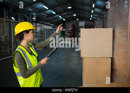 Female worker using digital tablet while working in factory Stock Photo