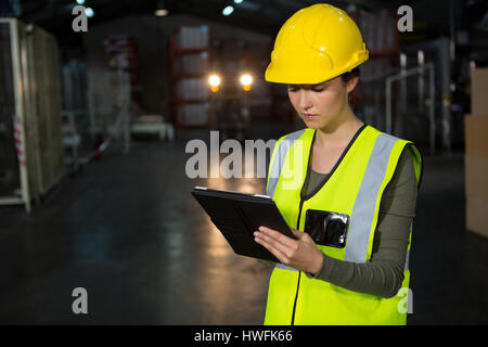 Portrait of beautiful young woman using tablet pc in factory Stock Photo
