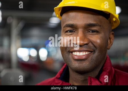 Close up portrait of male worker wearing yellow hard hat at factory Stock Photo