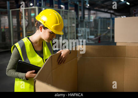 Female worker checking products in box at warehouse Stock Photo