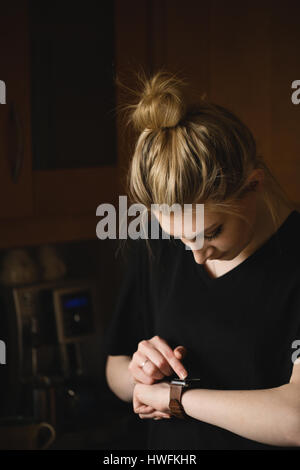 Woman using smart watch at home Stock Photo