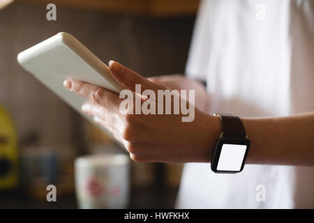 Mid-section of woman using digital tablet in kitchen at home Stock Photo
