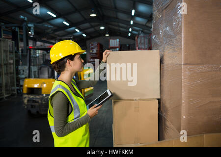 Female worker using digital tablet while working in warehouse Stock Photo