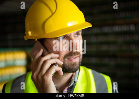 Close up of male worker talking on phone in factory Stock Photo