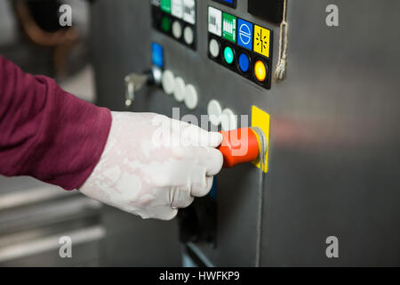 Cropped hand of worker operating machine in juice factory Stock Photo