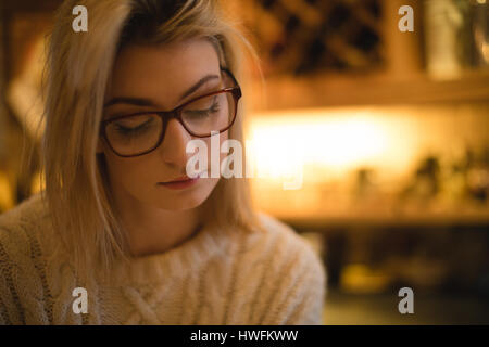 Thoughtful woman in kitchen at home Stock Photo