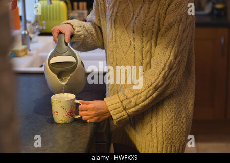 Woman preparing coffee in kitchen at home Stock Photo