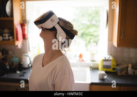 Woman using virtual reality headset at home Stock Photo