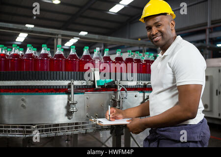 Portrait of young male worker noting in factory Stock Photo