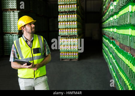 Young man examining bottles in warehouse Stock Photo