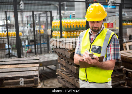 Confident male worker noting about products in warehouse Stock Photo