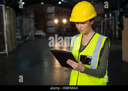 Portrait of beautiful young woman using tablet pc in factory Stock Photo