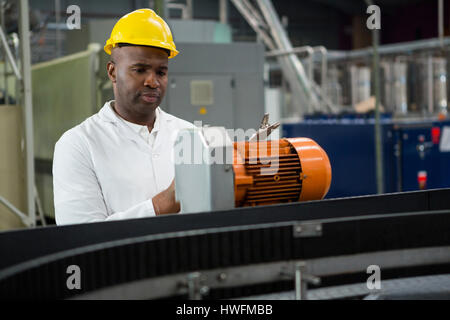 Engineer inspecting machines at juice factory Stock Photo