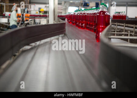 Red juice bottles on production line in manufacturing industry Stock Photo