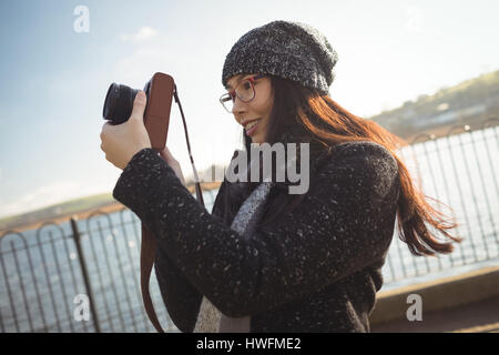 Smiling woman taking photos on digital camera Stock Photo