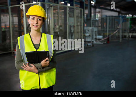 Portrait of beautiful young woman holding digital tablet in warehouse Stock Photo