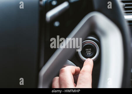 Engine start button and finger with shallow depth of field Stock Photo