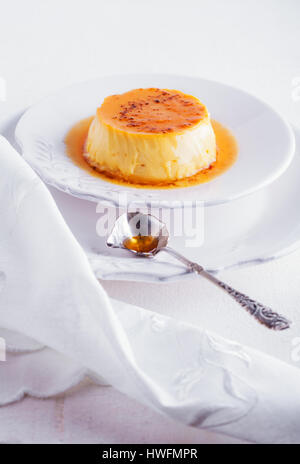 Creme Caramel on a white plate served on a table