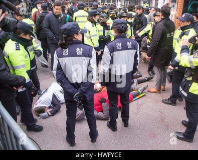 Seoul, South Korea. 21st Mar, 2017. Supporters of ousted president Park Geun-Hye lie on an alley as police officers watch them in front of Park's home before she leaves to the Seoul Central District Prosecutors' Office to undergo prosecution questioning in Seoul, South Korea. Park Geun-hye became South Korea's first democratically elected president to be ousted and she has been named a criminal suspect for allegedly abusing her power and colliding with her longtime friend Choi Soon-sil in extorting money from local conglomerates. Credit: Aflo Co. Ltd./Alamy Live News Stock Photo