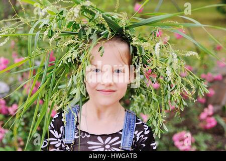 Baby girl in a wreath of wildflowers Stock Photo