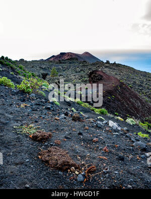 Cumbre Vieja, Fuencaliente. La Palma.  A view along the volcano's winding ridge and geological land formation. Very little vegetation grows in the lava rock of Cumbre Vieja region.  It's a bright day with fast moving clouds. Stock Photo