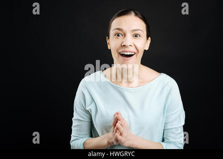 Shocked young woman keeping hands together Stock Photo