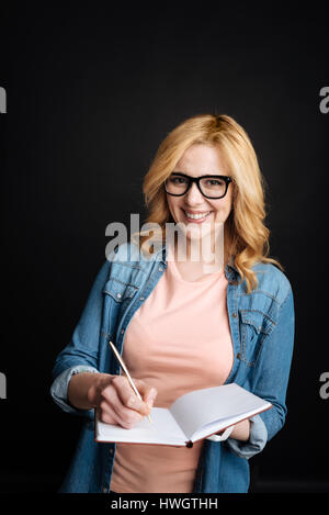 Young blonde while making notes Stock Photo