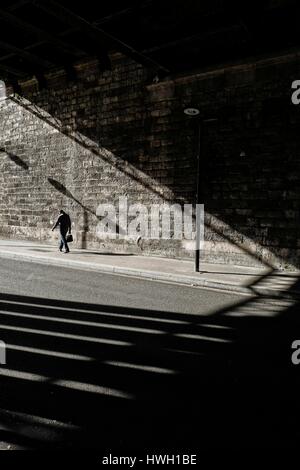 France, Paris, Man walking under a bridge Stock Photo