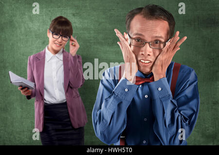 Asian nerd man looking shy with beautiful teacher behind him on class Stock Photo