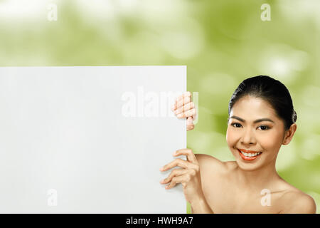 Pretty asian woman holding blank banner over blur background Stock Photo