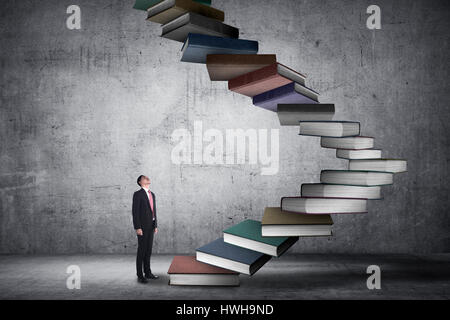 Business person step up flying book that look like stair. Career and education concept Stock Photo