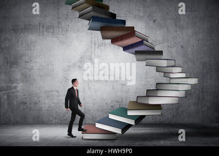 Business person step up flying book that look like stair. Career and education concept Stock Photo