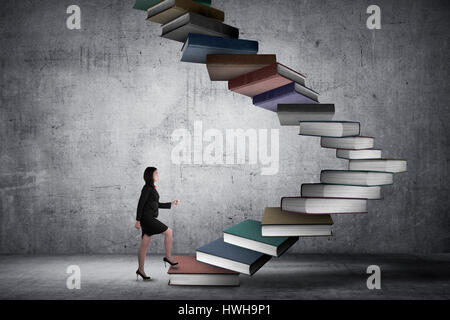 Business person step up flying book that look like stair. Career and education concept Stock Photo