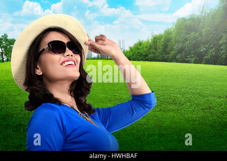 Young asian tourist wearing sunglasses and hat on the city park Stock Photo