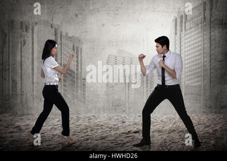 Business man and woman fighting. Working competition concept Stock Photo