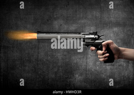 Man hand holding gun and firing it Stock Photo