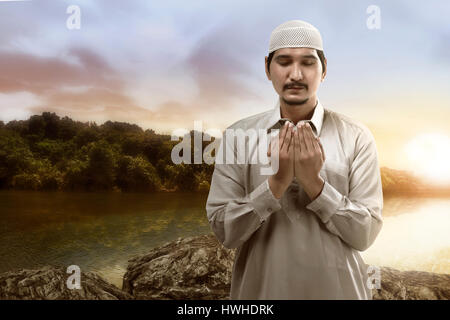 Image of young muslim man praying on the lake Stock Photo