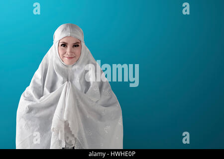 Asian muslim woman pray to god with green background. wearing white veil Stock Photo