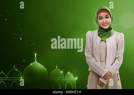 Young asian muslim woman give smile with green background template your giftcard Stock Photo
