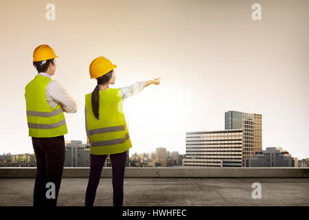 Back view of two architect looking the city from rooftop Stock Photo