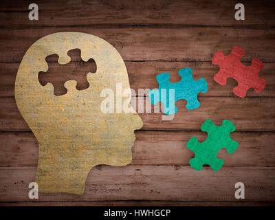 Puzzle head brain concept. Human head profile made from brown paper with a jigsaw piece cut out. Choose your personality that suit you Stock Photo