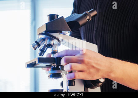 close-up of scientist hands with microscope, examining samples Stock Photo