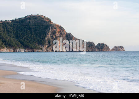 Castle Rock of Cleopatra beach in Alanya Turkey with sea and sand on front plan and rock covered with pine forests on bacground Stock Photo