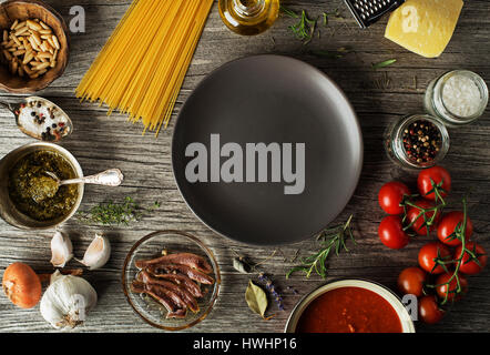 Spaghetti with ingredients for cooking pasta on wooden background Stock Photo