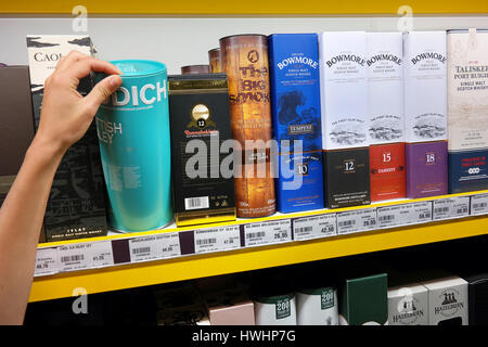 A customer picks a box with a bottle of whisky at a shop. Stock Photo
