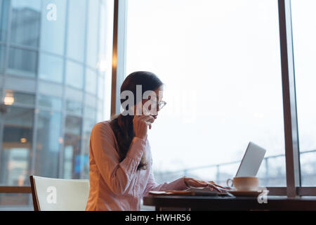 Businesswoman speaking on mobile phone and networking Stock Photo
