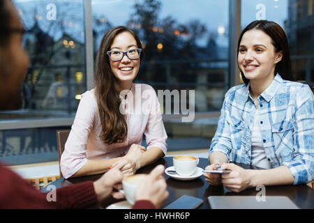 Joyful friends or co-workers having discussion by cup of coffee Stock Photo