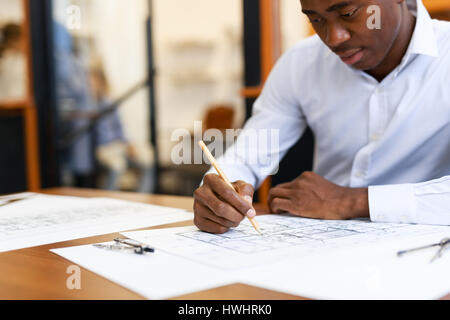 Young specialist sketching plan of new construction project Stock Photo
